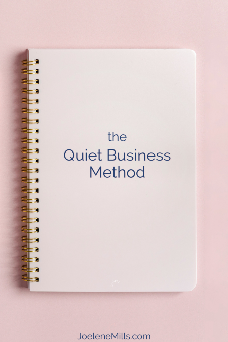 Spiral notebook on pink background with text "The Quiet Business Method"—framework for introverted entrepreneurs and quiet marketing.