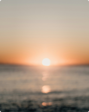 Blurry sunset over the ocean for the blog post: “Your big goals aren’t too big. They’re just blurry."