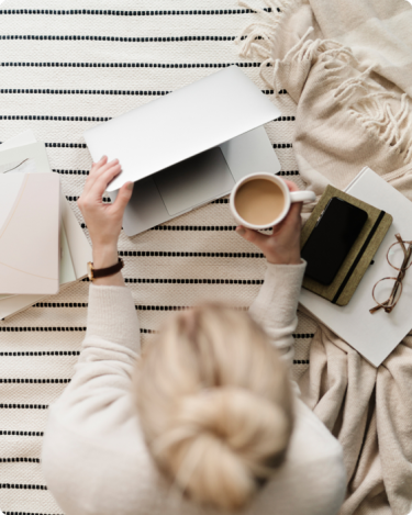 Woman holding coffee at laptop with calm focus—visual for Monday Motivation blog post on how to protect your energy and set boundaries in business.