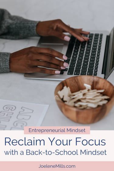 A woman's hands on  keyboard with a child's school work beside her and the words "Reclaim Your Focus with a back-to-school mindset"
