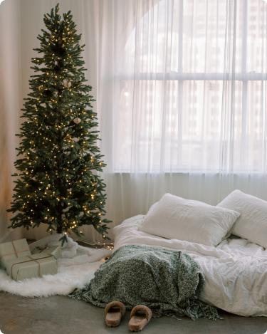 An empty room with slippers by the bed, a christmas tree representing a drop in December blog engagement