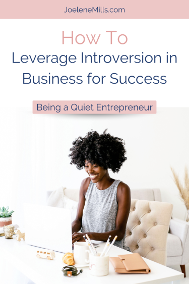 A pin for a blog about introversion in busines. A woman sitting at her desk with th words how to leverage introversion in business for success overlayed