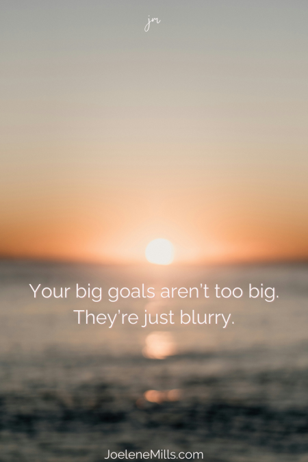 Blurry sunset over the ocean with quote text: “Your big goals aren’t too big. They’re just blurry."