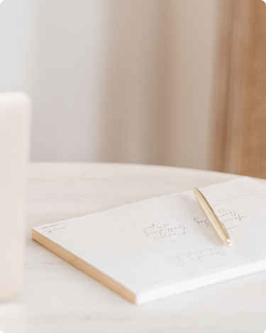 Minimal planner with gold pen on desk, for the blog post: “How to Bring Clarity Into Your Audience’s Planning Mode.”