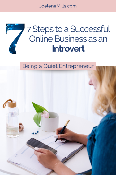Woman working alone at her desk and looking at her phone with the words "7 steps to a successful onine business as an introvert"
