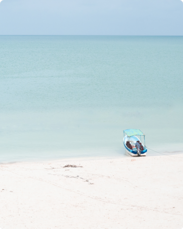 Small boat on calm beach with overlay text “How to Set Your Summer Hours”—ideal for introverted entrepreneurs seeking sustainable business routines.