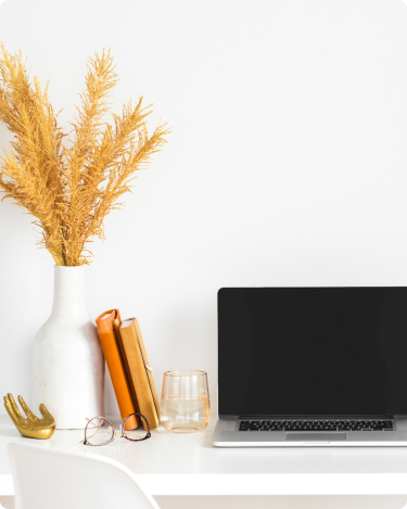 Warm desk scene with yellow cup, notebooks, and vase—minimalist workspace reflecting a Fall Blogging Slowdown mood.