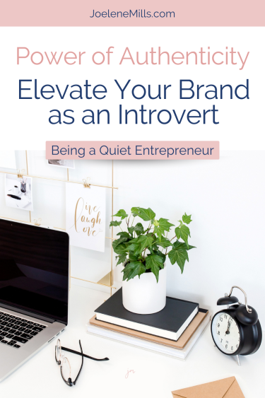 A white desk with a laptopn, plant, clock, glasses, and the words power of authenticity-elevate your brand as an introvert.